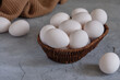© Tereza - Fresh white eggs in a basket on a gray background