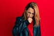© Krakenimages.com - Hispanic young woman wearing black leather jacket feeling unwell and coughing as symptom for cold or bronchitis. health care concept.