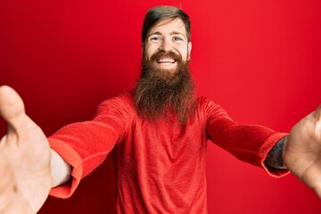 Poster - Redhead man with long beard wearing casual clothes looking at the camera smiling with open arms for hug. cheerful expression embracing happiness.