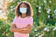 © Krakenimages.com - Young african american girl wearing medical mask standing at the park.