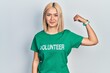 © Krakenimages.com - Beautiful blonde woman wearing volunteer t shirt strong person showing arm muscle, confident and proud of power