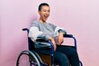 © Krakenimages.com - Beautiful hispanic woman with short hair sitting on wheelchair winking looking at the camera with sexy expression, cheerful and happy face.