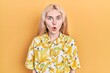 © Krakenimages.com - Beautiful caucasian woman with blond hair wearing colorful shirt scared and amazed with open mouth for surprise, disbelief face