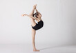 © klavdiyav - preteen girl gymnast trains on white background in black leotard. children's professional sports. rhythmic gymnastics.