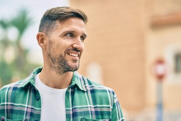 Wall Mural - Young caucasian man smiling happy standing at the city.