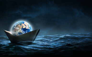 Wall Mural - Planet earth in a paper boat floating in the ocean. Faith or religion conceptual theme.