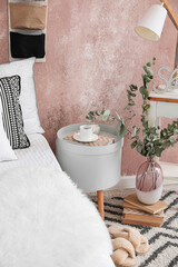 Poster - Bedside table with cup of coffee in interior of stylish bedroom