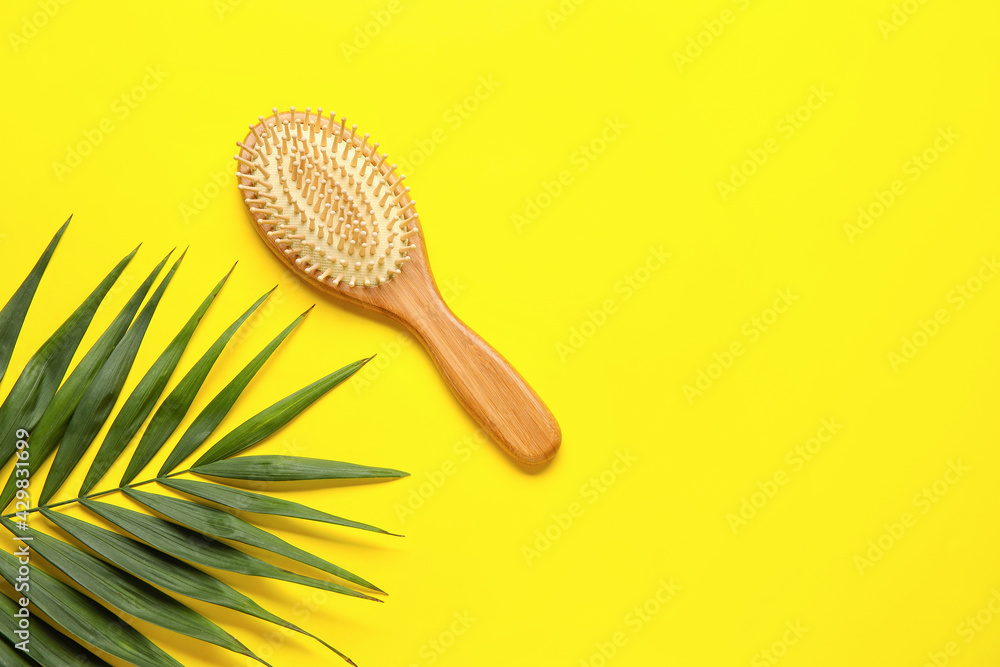 Wooden hair brush on color background