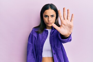 Young brunette woman wearing casual clothes doing stop sing with palm of the hand. warning expression with negative and serious gesture on the face.