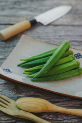 Farm fresh raw okra on wooden rustic table