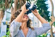 © Krakenimages.com - Middle age hispanic woman smiling happy looking for new opportunity using binoculars at the city.