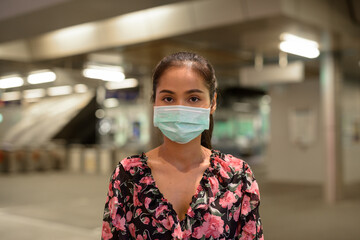 Wall Mural - Woman wearing face mask for protection against coronavirus Covid-19 outdoors at night