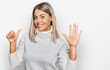 © Krakenimages.com - Beautiful blonde woman wearing casual turtleneck sweater showing and pointing up with fingers number six while smiling confident and happy.