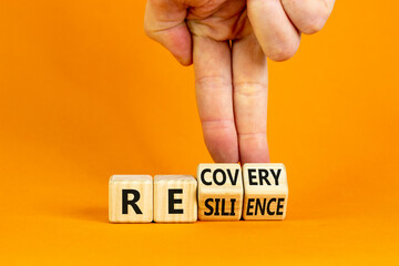 Wall Mural - Recovery and resilience symbol. Businessman turns cubes and changes the word 'recovery' to 'resilience'. Beautiful orange background. Business and recovery - resilience concept. Copy space.