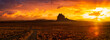 Striking panoramic landscape view of a dirt road in the dry desert with a mountain peak in the background. Colorful Sunset Sky Art Render. Taken at Shiprock, New Mexico, United States.