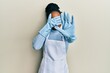© Krakenimages.com - African american woman with braided hair wearing cleaner apron and gloves covering eyes with hands and doing stop gesture with sad and fear expression. embarrassed and negative concept.
