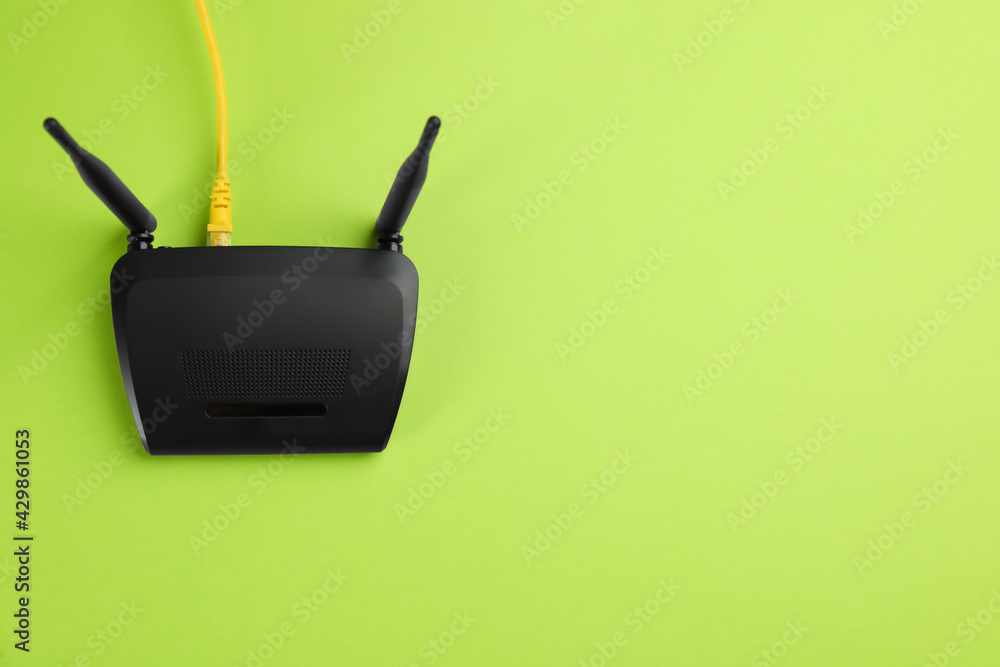 Modern Wi-Fi router on green background, top view. Space for text - obrazy, fototapety, plakaty 
