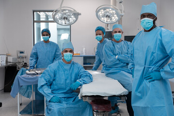 Wall Mural - Diverse surgeons wearing face masks and protective clothing in operating theatre