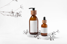 Bottles Of Natural Hair Cosmetics And Flowers On White Background