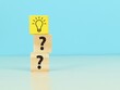 © Ekahardiwito - Question mark concept. Wooden cubes with light bulb and question mark symbol.