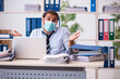 © Elnur - Young male employee working in the office during pandemic