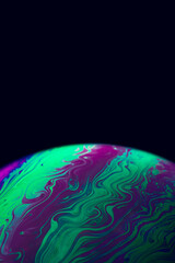 Wall Mural - Bubble macro. Abstract galaxy background with globe planet earth in universe space with sunlight on dark background. Macro soap bubble made with dish soap.