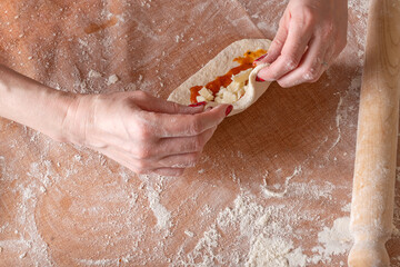 Making dough by female hands brown table background,view from above.