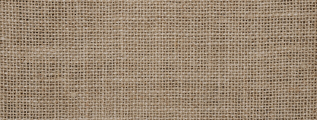 Hessian sackcloth burlap woven texture background, Cotton woven fabric close up with flecks of varying colors of beige and brown, with copy space for text decoration.