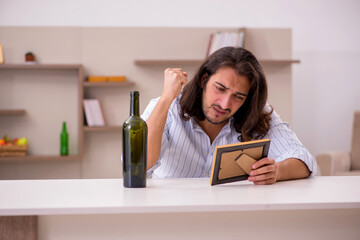 Poster - Young man drinking alcohol at home in unhappy love concept