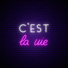 C'est la vie neon signboard. It's a life on french. Glowing french quote on brick wall background. Vector banner in neon style.