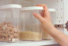 Woman Taking Brown Rice From A Kitchen Cupboard
