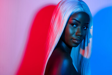 Photo of young stunning peaceful african girl in artificial wig enjoying nightlife party isolated on gradient background