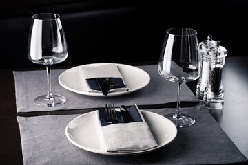 Elegant table setting white plates on black wooden table