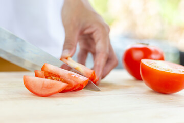 Wall Mural - red tomatoes and slices on wooden cutting board