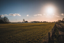 Scenic View Of The Vast Field With A Fence In The Farmland Against A Bright Sunlight