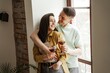 © Ivan - Lovely couple hugging with glasses of wine at home, romantic vibes. Happy young family moved to new apartment