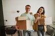 © Ivan - Happy couple holding keys of new apartment with boxes. Young family moving to new apartment