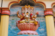 View of wall art of Hindu god Brahma. Brahma, the four-headed lord, sits on a lotus flower. Religious image on the temple in India.