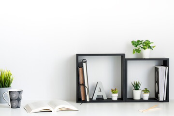 Wall Mural - Home office. A desk against a white wall. Copy space. An open book. Geometric composition. Squares.