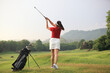 © sittinan - Beautiful golf course at the sunset, sunrise time,female golf player on professional golf course. Golfer with golf club taking a shot