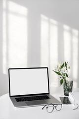 	
Laptop computer with empty blank mockup screen over white modern living room design. Work place, home office interior. Business, web site advertisement, workspace concept