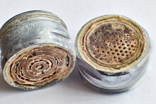 Two old limescale faucet aerators close up