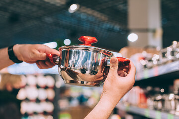 Wall Mural - A man in a shop selects a new cooking pot.