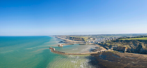 Sticker - La vue panoramique de la plage, le port et la digue du port en Bessin en France, en Normandie, dans le Calvados, au bord de la Manche.