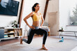 © InsideCreativeHouse - Slim african-american young woman in fitness outfit exercising at home. Healthy fit young woman in activewear sitting on mat in living-room and doing sit-ups
