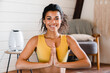 © InsideCreativeHouse - Close up portrait of a serene young sporty african woman meditating indoors. Online meditation. Calm black woman practicing yoga in front of laptop at home, meditating in lotus position
