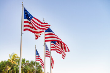 Sticker - Group of american flags waving with blue sky on the background