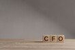 Wood cubes with acronym 'CFO' - 'Chief Fiinancial Officer' on a beautiful wooden table, studio background. Business concept and copy space.