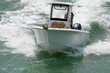 Slightly elevated head on view of a small white fishing boat speeding on Biscayne Bay near Miami Beach,Florida