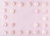 Fototapeta Lawenda - Frame made of flowers on pink background. Top view, flat lay.
